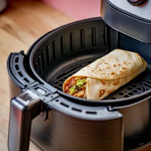 A-burrito-being-reheated-in-an-air-fryer-and-served-with-melted-cheese-and-fresh-toppings