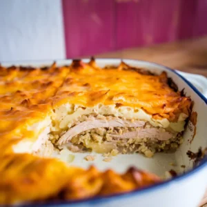 A-casserole-dish-fresh-out-of-the-oven-with-a-golden-brown-cheesy-topping-sliced-to-reveal-layers-of-mashed-potatoes-chicken-and-creamy-sauce