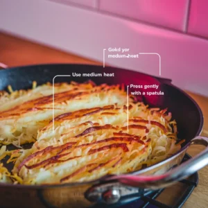 A-close-up-of-perfectly-golden-hash-browns-in-a-skillet-with-labeled-tips-like-Use-Medium-Heat-and-Press-Gently