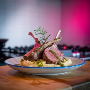 A-plate-of-lamb-chops-served-with-mashed-potatoes-drizzled-with-mint-sauce-and-garnished-with-fresh-rosemary-sprigs