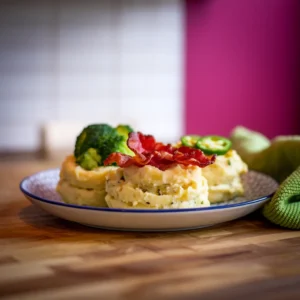 A-platter-featuring-multiple-twice-baked-mashed-potatoes-with-different-toppings—one-with-bacon-one-with-broccoli-and-one-with-jalapenos