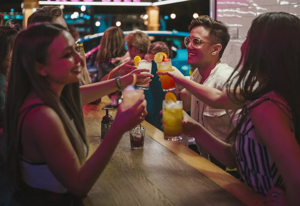 A-vibrant-interior-shot-of-a-Taco-Bell-Cantina-with-cocktails-on-the-table-paired-with-a-traditional-Taco-Bell-drive-thru-scene-emphasizing-their-unique-vibes